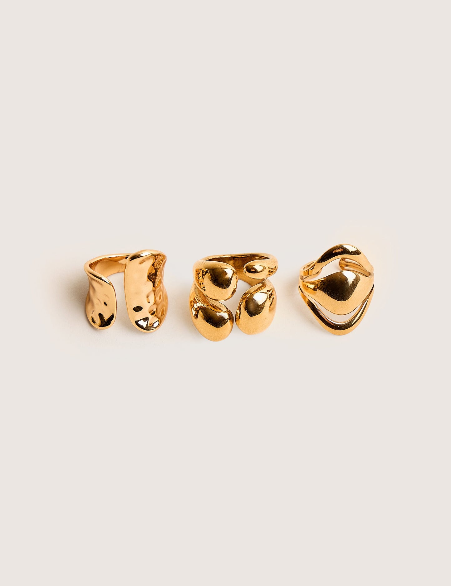 Trío de anillos apilables gruesos en dorado, con diseño abstracto