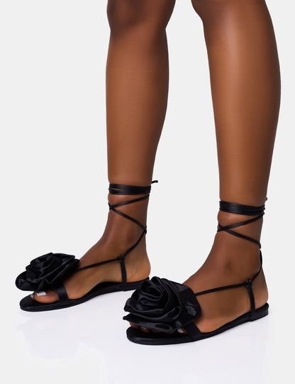Sandalias planas negras con cordones y flor corsage Magnolia