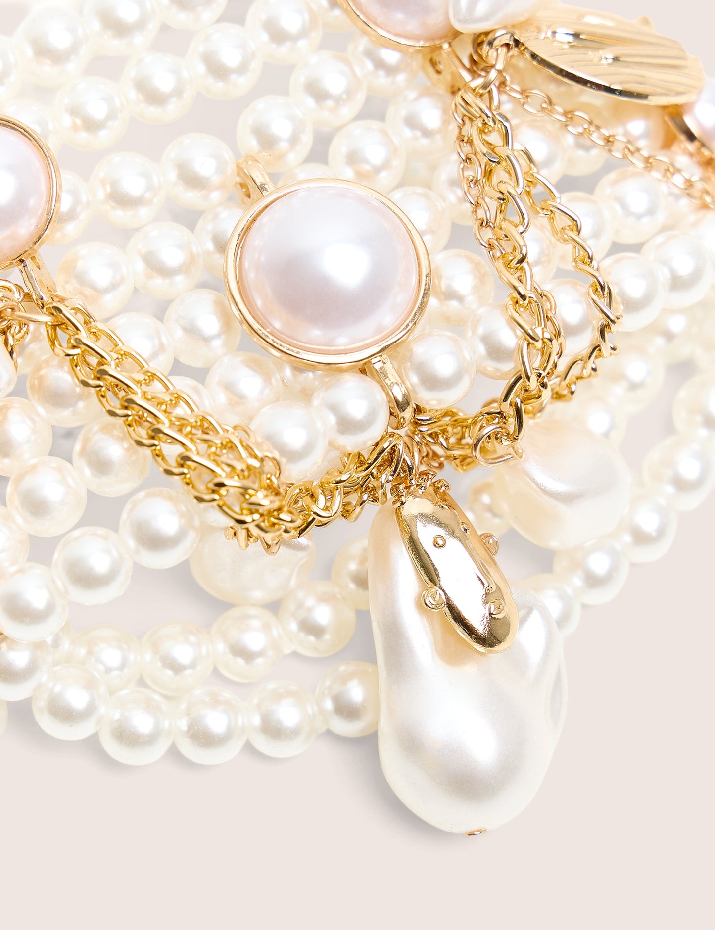 Pulsera de perlas en capas con dijes de oro