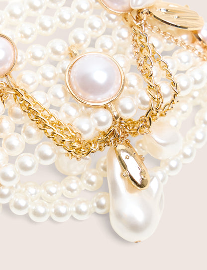Pulsera de perlas en capas con dijes de oro