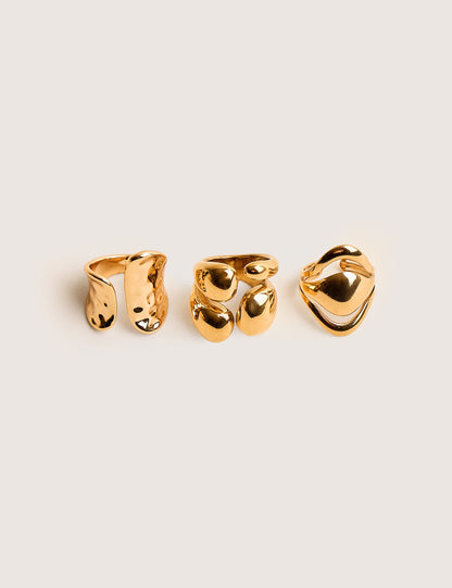 Trío de anillos apilables gruesos en dorado, con diseño abstracto