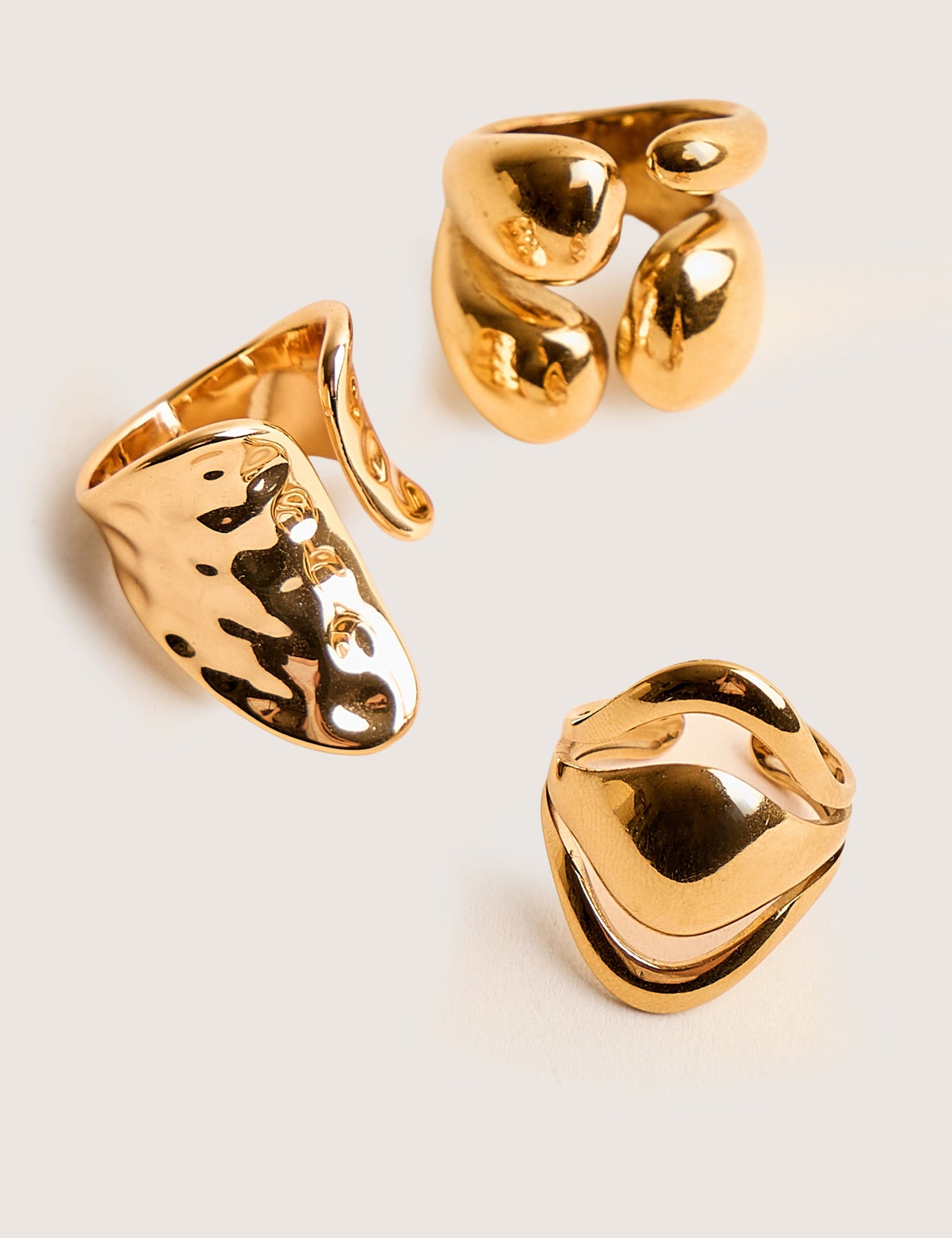 Trío de anillos apilables gruesos en dorado, con diseño abstracto